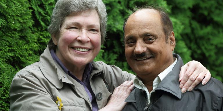 Woman with arms around man, both smiling 